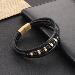 Detail shot of multi-layer black braided leather bracelet with gold magnetic steel clasp