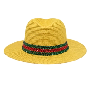 Détail du chapeau de paille jaune avec ruban de paillettes vertes et rouges brillantes