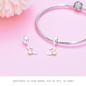 Close-up of S925 sterling silver bangle with 'Unique you are' text and musical note charm