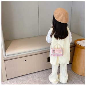 Detailed view of kids pink tweed bag with pearl handle, rabbit doll and metal chain