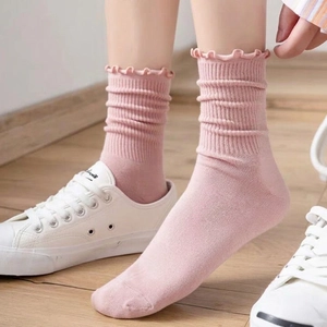 Pink Japanese style ruffle trim ribbed crew socks for women shown in a stylish slouchy look