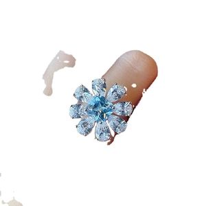 Flower-shaped silver ring with sky blue square center stone and white pear-cut petals
