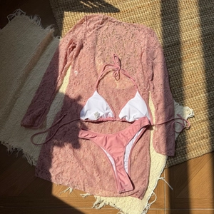 Detailed flat lay of pink lace long sleeve dress with three-piece bikini swimsuit set