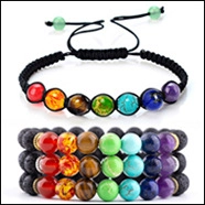 Detail view of 7 chakra natural volcanic stone beaded bracelets and black woven rope jewelry