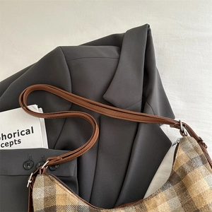 Plaid crescent underarm bag in retro brown fabric displayed on a minimalist grey blazer