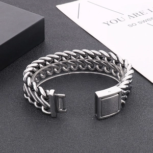 Detail of heavy stainless steel woven Cuban chain bracelet with secure square clasp