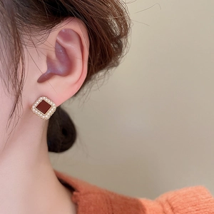 Boucles d'oreilles vintage carrées dorées avec émail rouge et perles sur un mannequin