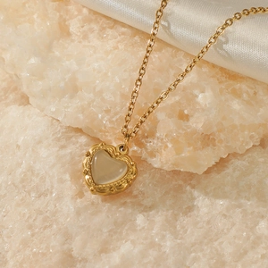Minimalist 14K gold plated heart necklace with translucent gemstone on raw stone texture