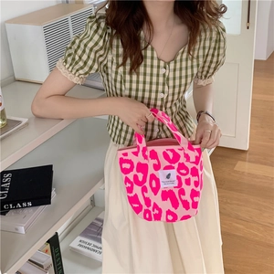 Pink leopard print canvas tote bag styled with a green checkered puff sleeve top