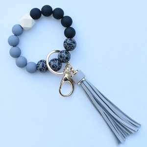 Close-up of leopard print silicone beads with grey tassel and golden keychain ring