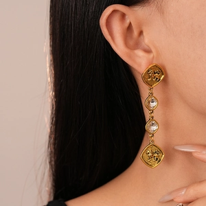 Détail de boucles d'oreilles lion vintage dorées avec strass portées par un modèle