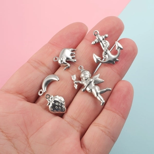 Five stainless steel charms including elephant anchor angel moon and strawberry shapes