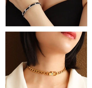 Close-up of gold chain necklace and silver leather-woven bracelet on a model