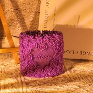 Detail of rose embossed pillar candle with heart Love engraving in purple wax