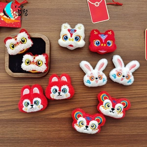 Detailed plush Chinese New Year lion and rabbit embroidery patches on a wood background