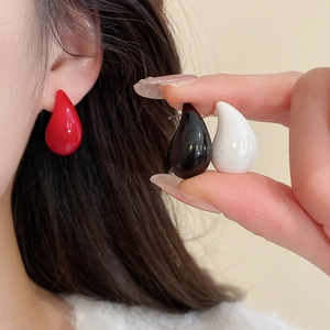 Detail of colorful acrylic teardrop earrings in red, black, and white colors