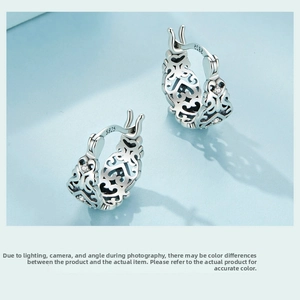Macro detail of S925 sterling silver hoop earrings with hollow retro floral patterns
