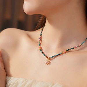 Détail d'un collier de perles multicolores vintage avec pendentif soleil doré sur mannequin