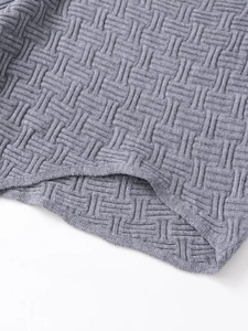 Detail view of the thick gray textured knit fabric with a cross-stitch weave pattern