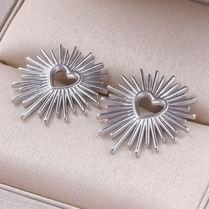 Macro shot of silver 304 stainless steel heart starburst stud earrings in a jewelry box