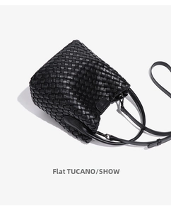 Close-up of black leather woven bucket bag showing intricate intrecciato texture and straps
