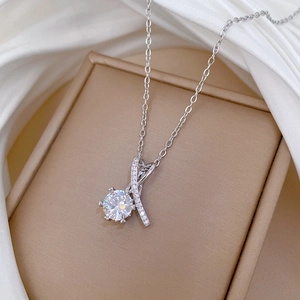 Vue macro d'un pendentif cœur en argent avec zircon sur fond de soie blanche élégante