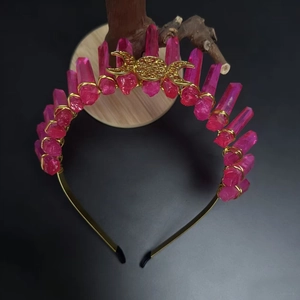 Macro detail of a pink crystal crown headband with golden moon and sun metal ornaments