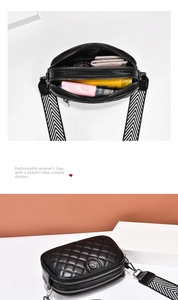 Detailed view of black quilted crossbody bag with dual zippers and wide striped strap