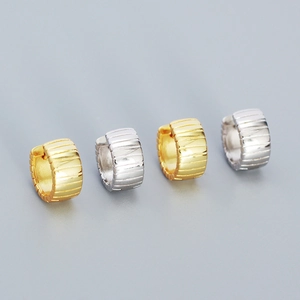 Detailed close-up of gold and silver sterling silver hoop earrings with striped texture