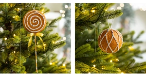 Close-up of gingerbread style lollipop and ball ornaments on a lit Christmas tree