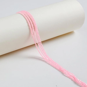 Pink faceted zircon crystal beads for DIY jewelry making displayed on white column