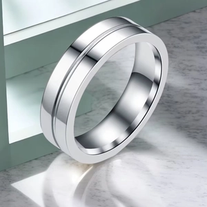 Détail macro d'une bague en acier inoxydable argenté avec rainure sur marbre