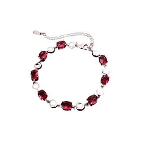Elegant silver bracelet with red oval zircons and circular links on a white background