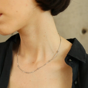 Minimalist silver beaded snake chain necklace shown on a model neck in lifestyle style