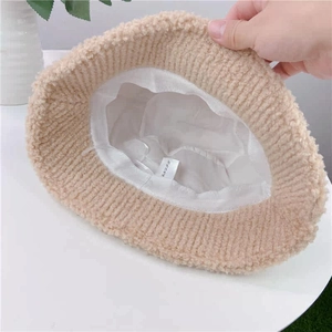 Detail of beige fleece bucket hat interior showing adjustable drawstring and soft lining