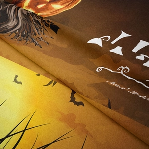 Detail macro shot of Halloween tapestry showing soft flannel texture and pumpkin print