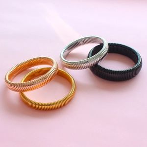 Detail of four metallic stretch Tubogas bracelets in gold, silver, rose gold and black