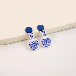 Macro detail of Chinese porcelain style vase earrings with intricate blue patterns