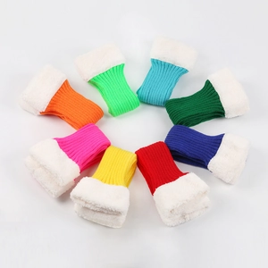 Top view of eight colorful knitted leg warmers with white faux fur cuffs in a circle
