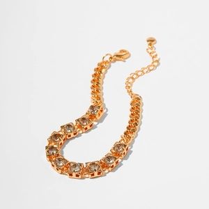 Detail of gold plated bracelet featuring square cubic zirconia stones and adjustable clasp