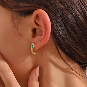 Boucles d'oreilles serpent en or 18 carats avec cristaux verts sur l'oreille