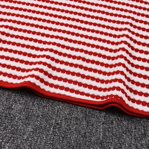 Gros plan détaillé du tissu en maille rayé rouge et blanc avec couture de bordure