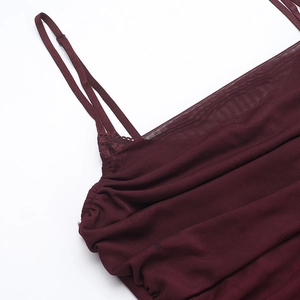 Gros plan sur la robe en dentelle bordeaux montrant les bretelles et les plis du buste