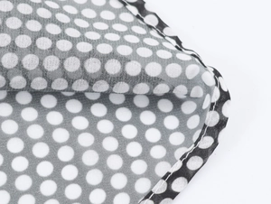 Detail of white polka dot fabric on black chiffon with high-quality stitching craft