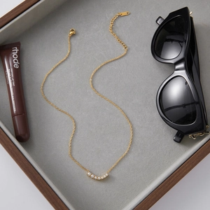 Close-up of 18K gold stainless steel chain with six white gradient pearls in jewelry tray