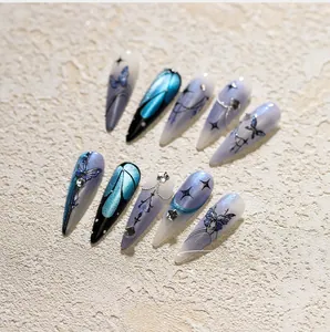 Detailed close-up of blue and purple stiletto nails with butterfly and star decorations