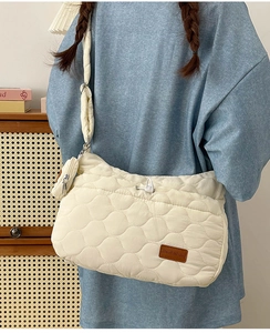 Détail du sac bandoulière matelassé avec petit porte-monnaie rond amovible sur la sangle
