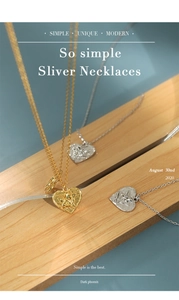 Detail of heart angel relief pendant in gold and silver finish on a wooden block