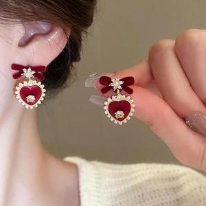Detail of red velvet bow earrings with heart pendant featuring pearls and golden rose