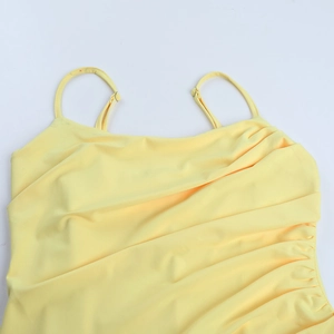 Detail of adjustable thin straps and elegant draped ruching on a yellow maxi dress
